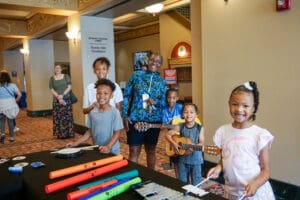 Kids and adults enjoying instruments and crafts in the Strand Theatre lobby before a family performance