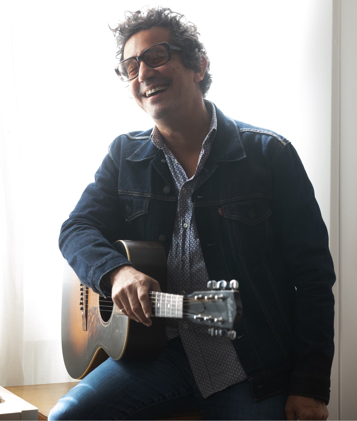 AJ Croce smiling and holding guitar