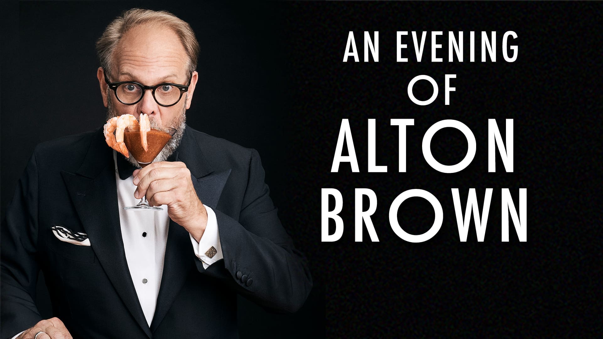 Chef Alton Brown holding a shrimp cocktail in a martini glass