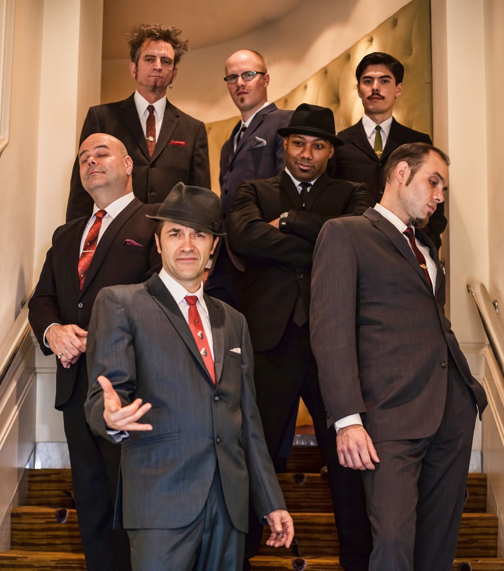 Members fo Cherry Poppin' Daddies standing on steps with instruments