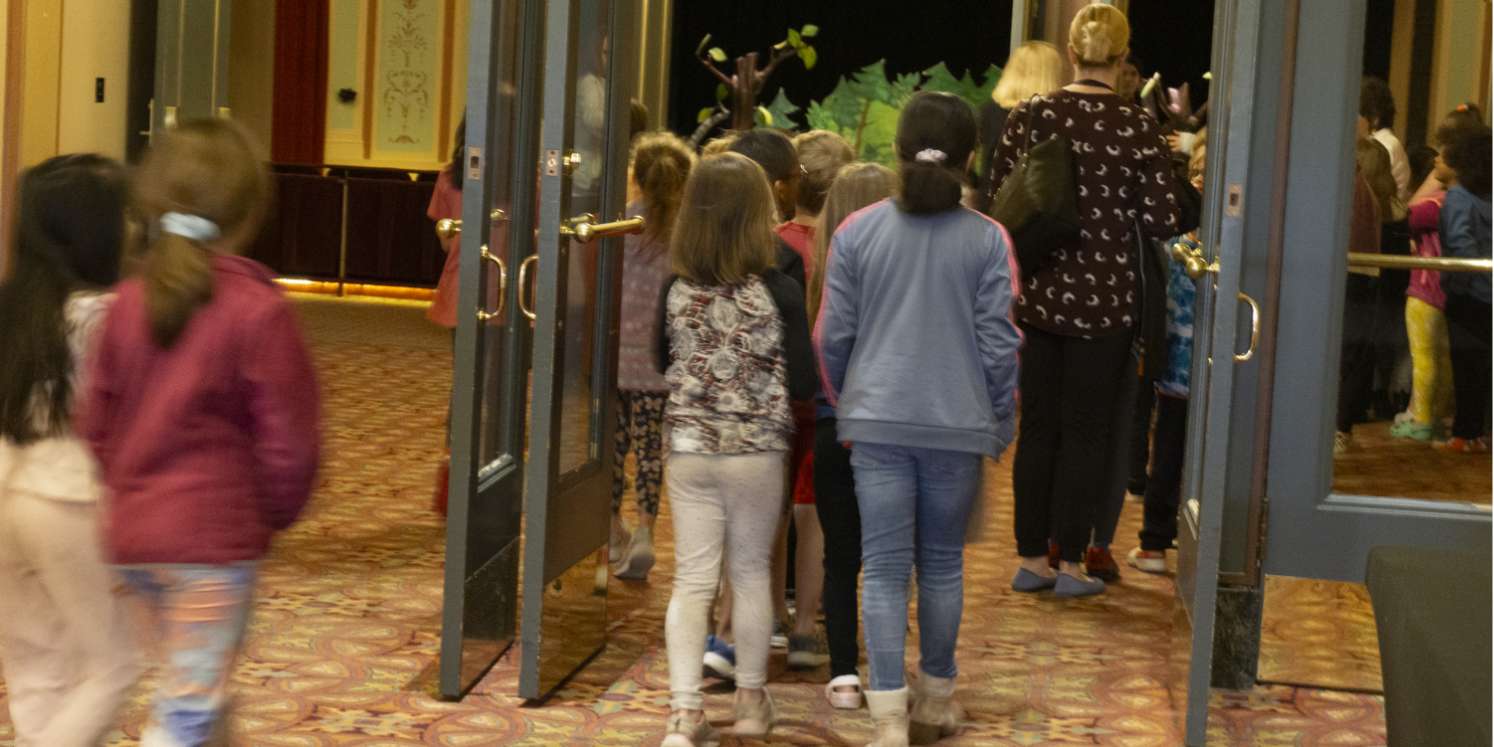 Children and teachers enter the Strand Theatre