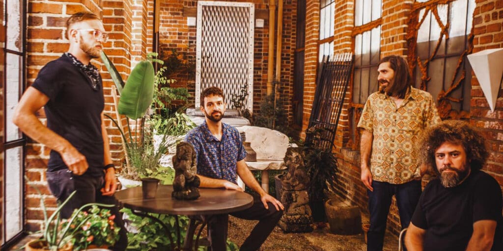 the group Dopapod sitting in a courtyard