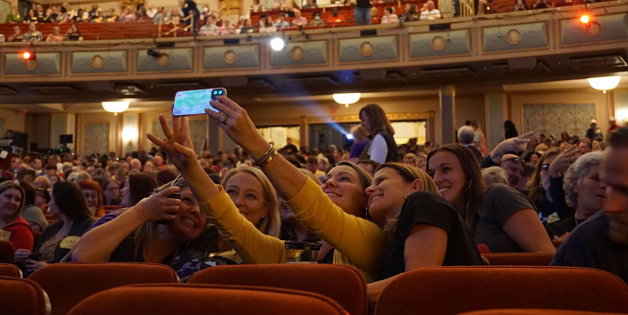 fans taking a selfie in the seats of the Strand Theatre before a show