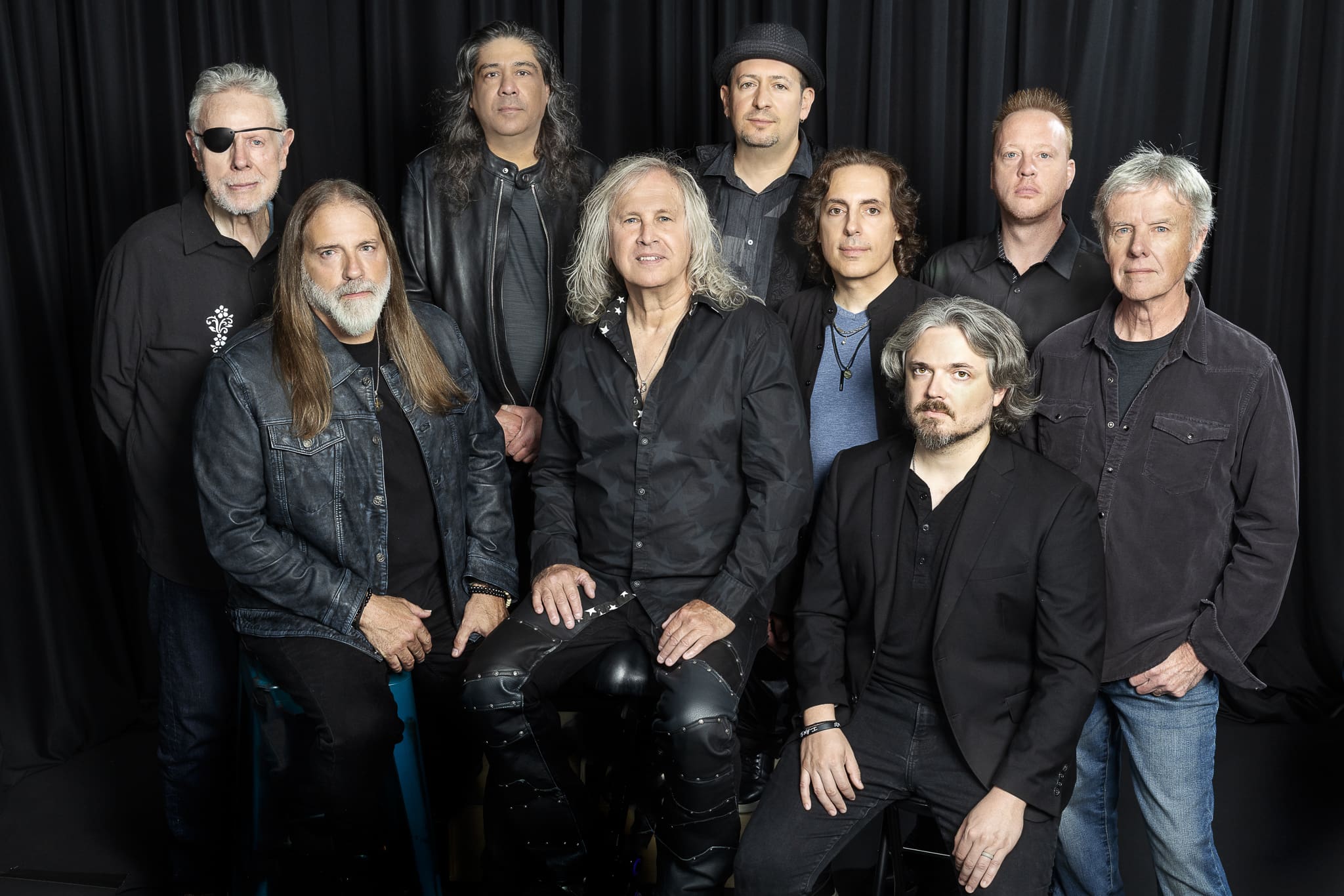 Group photo of the band Kansas wearing all black and denim