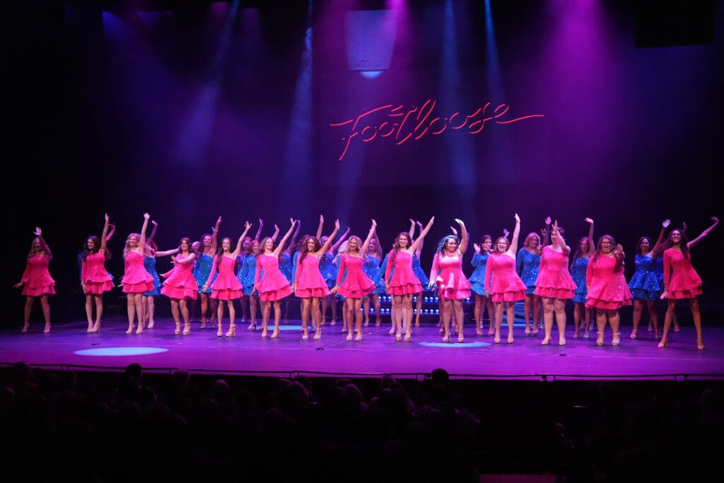 Miss Pennsylvania contestants lined up on stage in hot pink and bright blue dresses