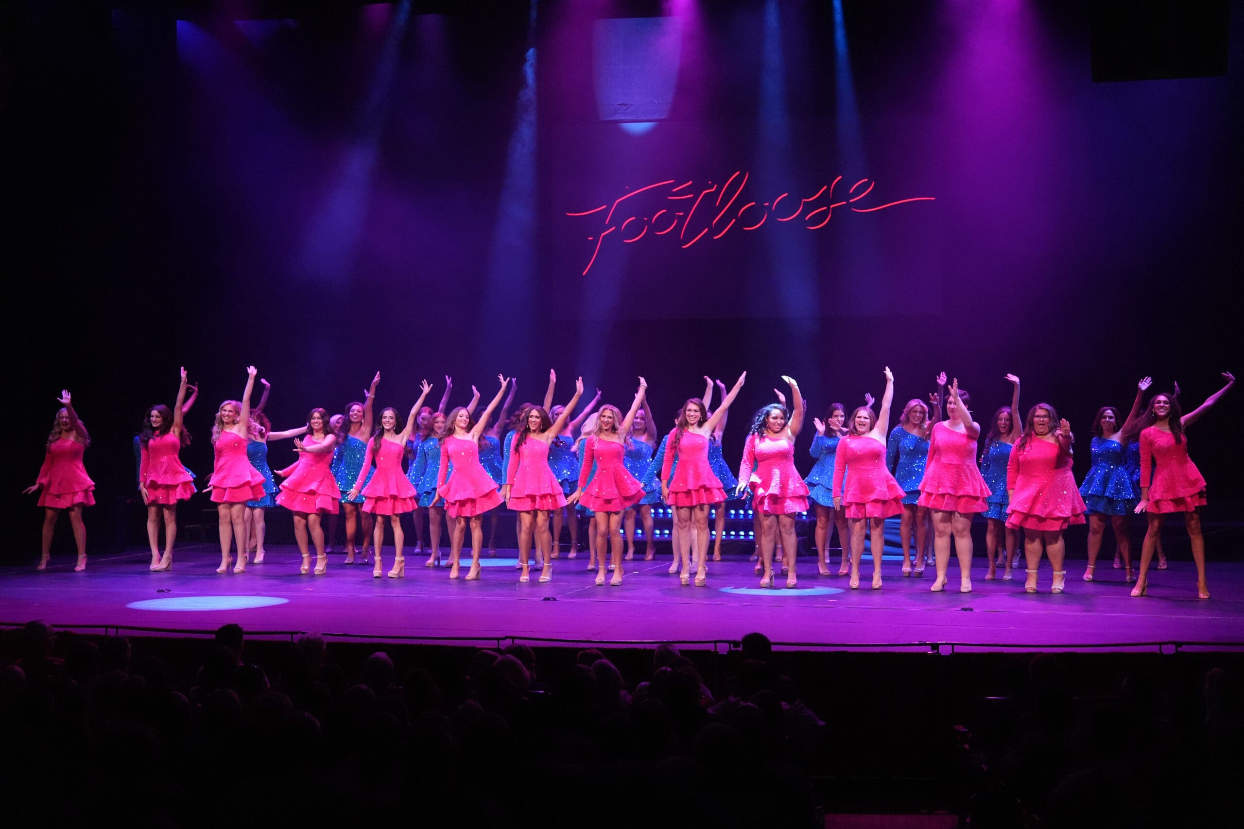 Miss Pennsylvania contestants lined up on stage in hot pink and bright blue dresses