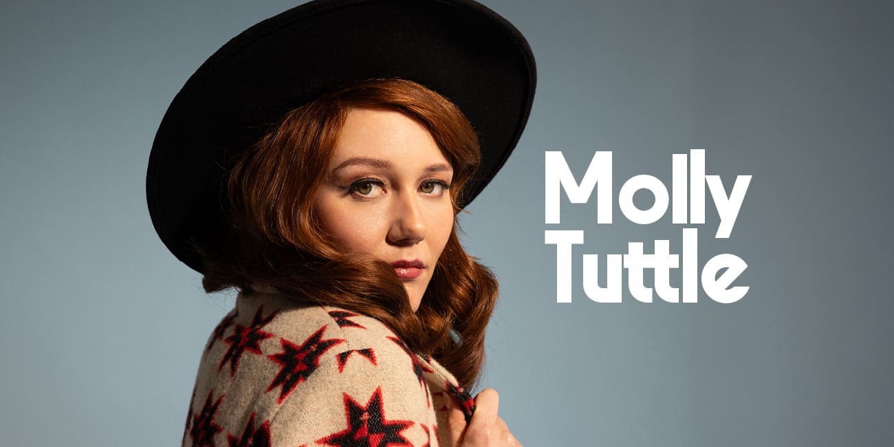 color portrait of Molly Tuttle with side glance over her right shoulder and wearing a black round hat