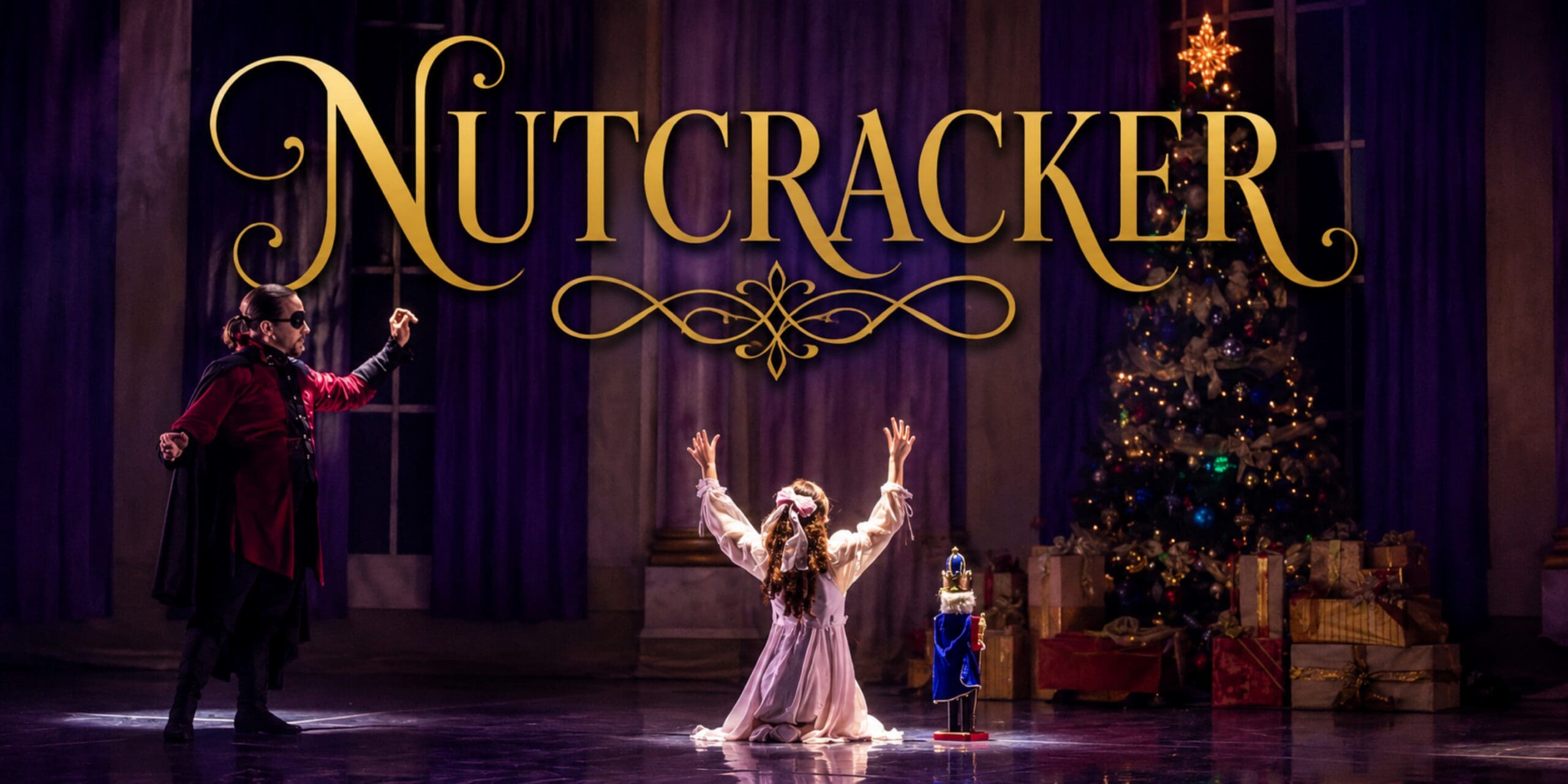 scene from The Nutcracker with Clara on her knees in front of the Christmas tree with a nutcracker next to her and Drosselmeyer to her left