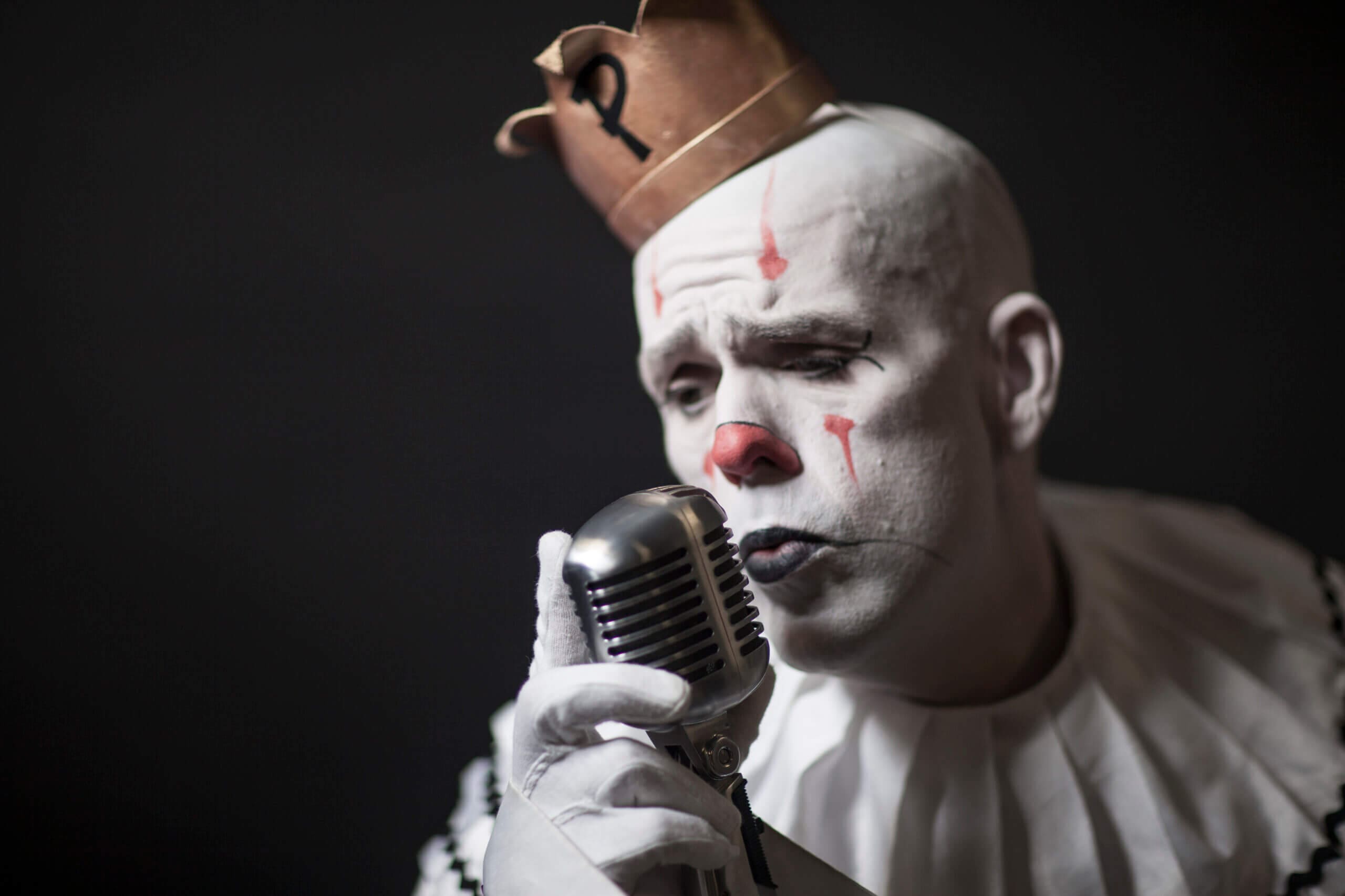 Puddles the clown singing into a vintage microphone