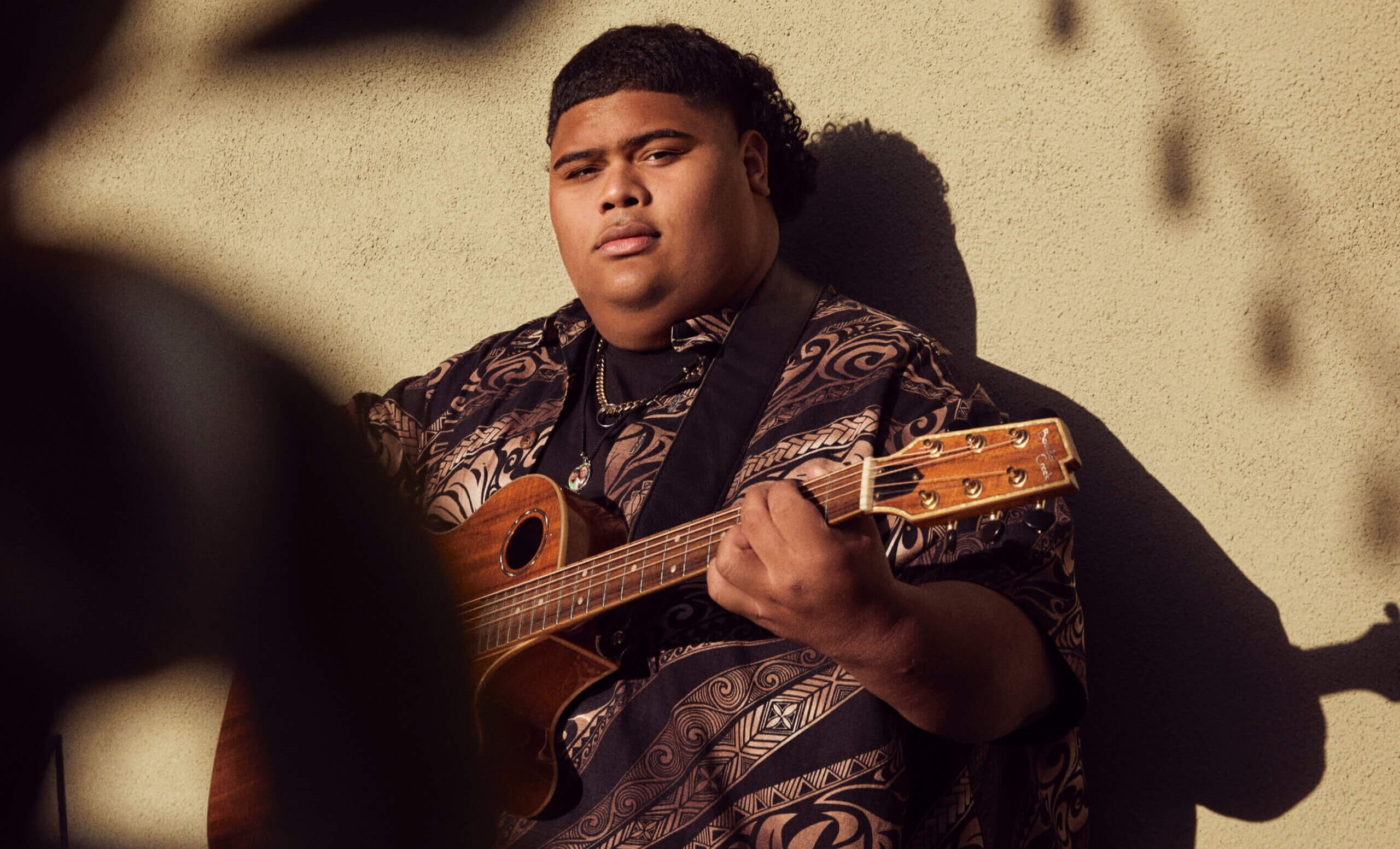 Iam Tongi holding guitar