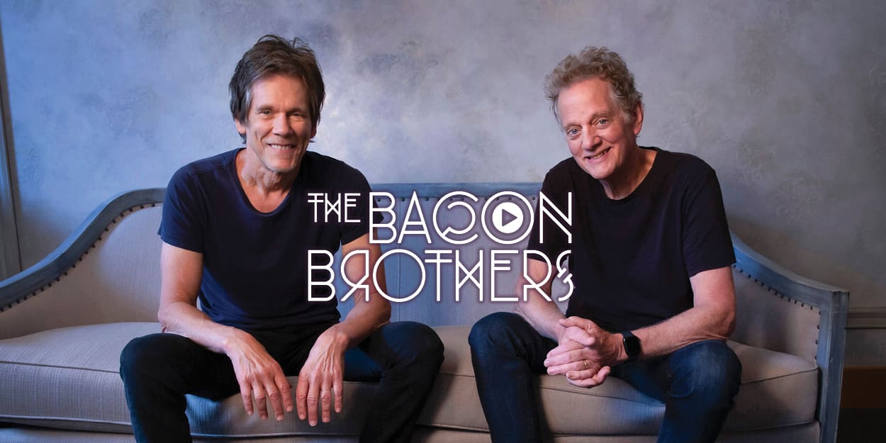 Kevin & Michael Bacon sitting on a couch smiling