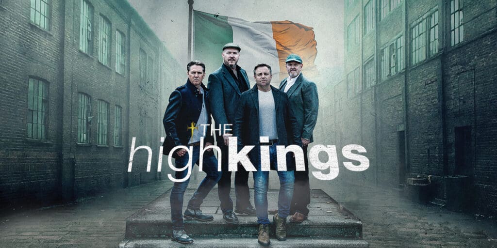 Irish folk group The High Kings standing in an alley with the Irish flag behind and thir band name in front