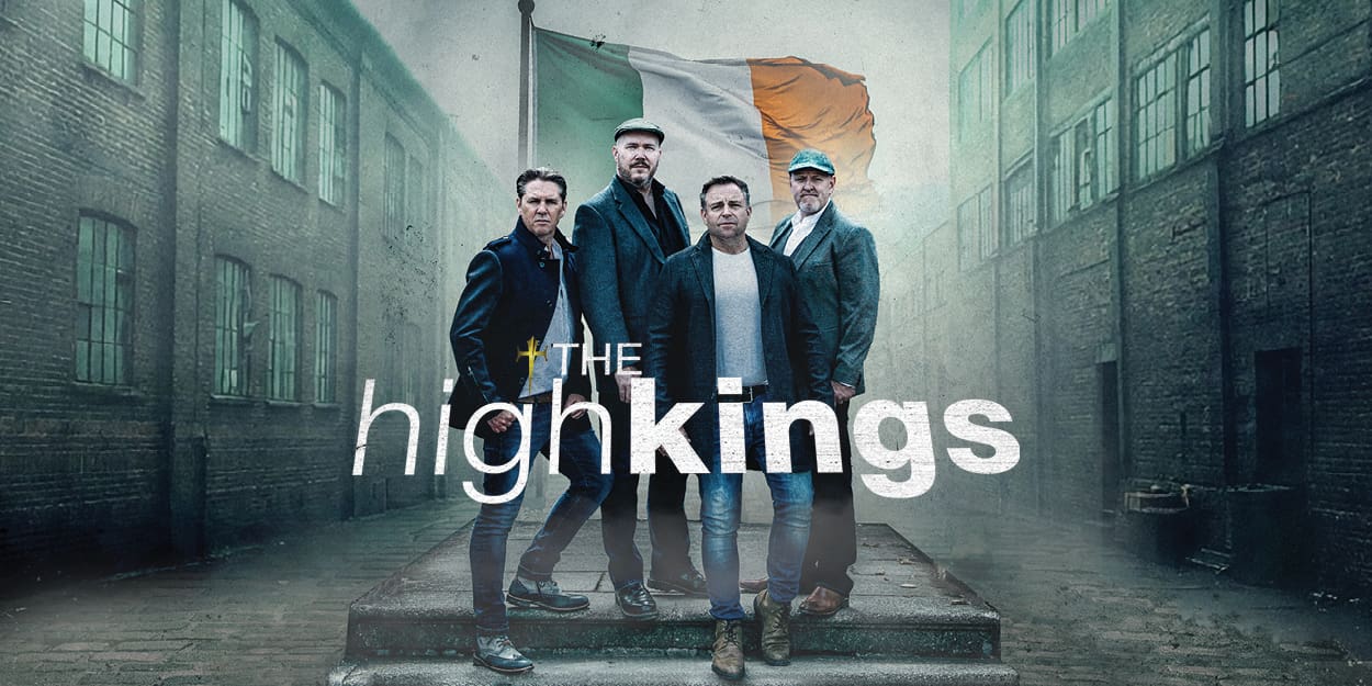 Irish folk group The High Kings standing in an alley with the Irish flag behind and thir band name in front