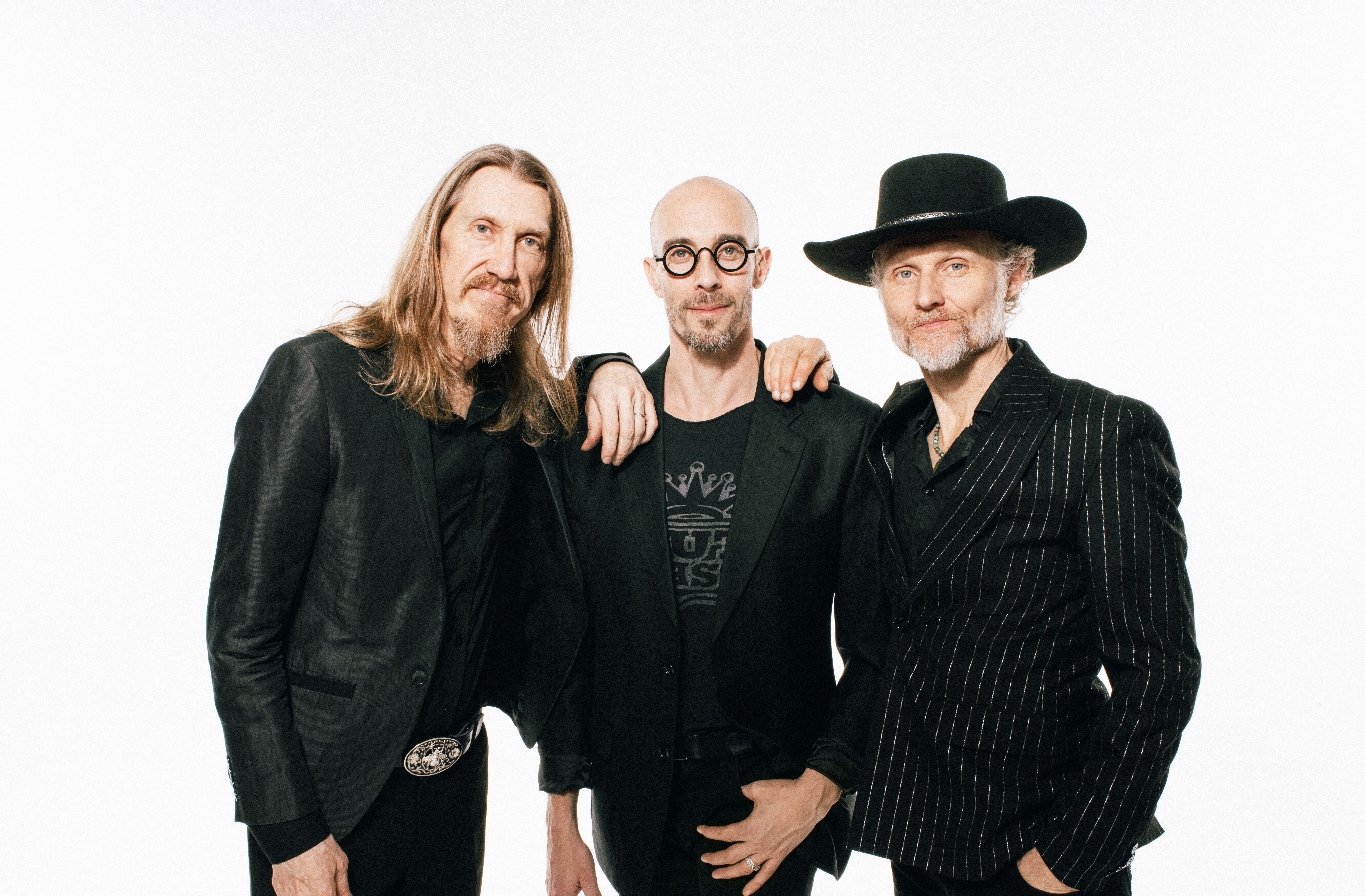 The Wood Brothers all wearing black, standing against a white background