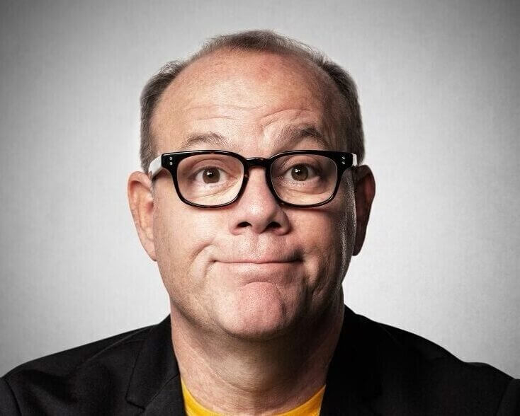 Tom Papa headshot in yellow shirt with black jacket