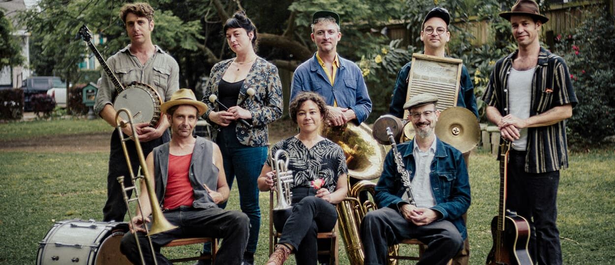 Members of the band Tuba Skinny posing outdoors with their instruments