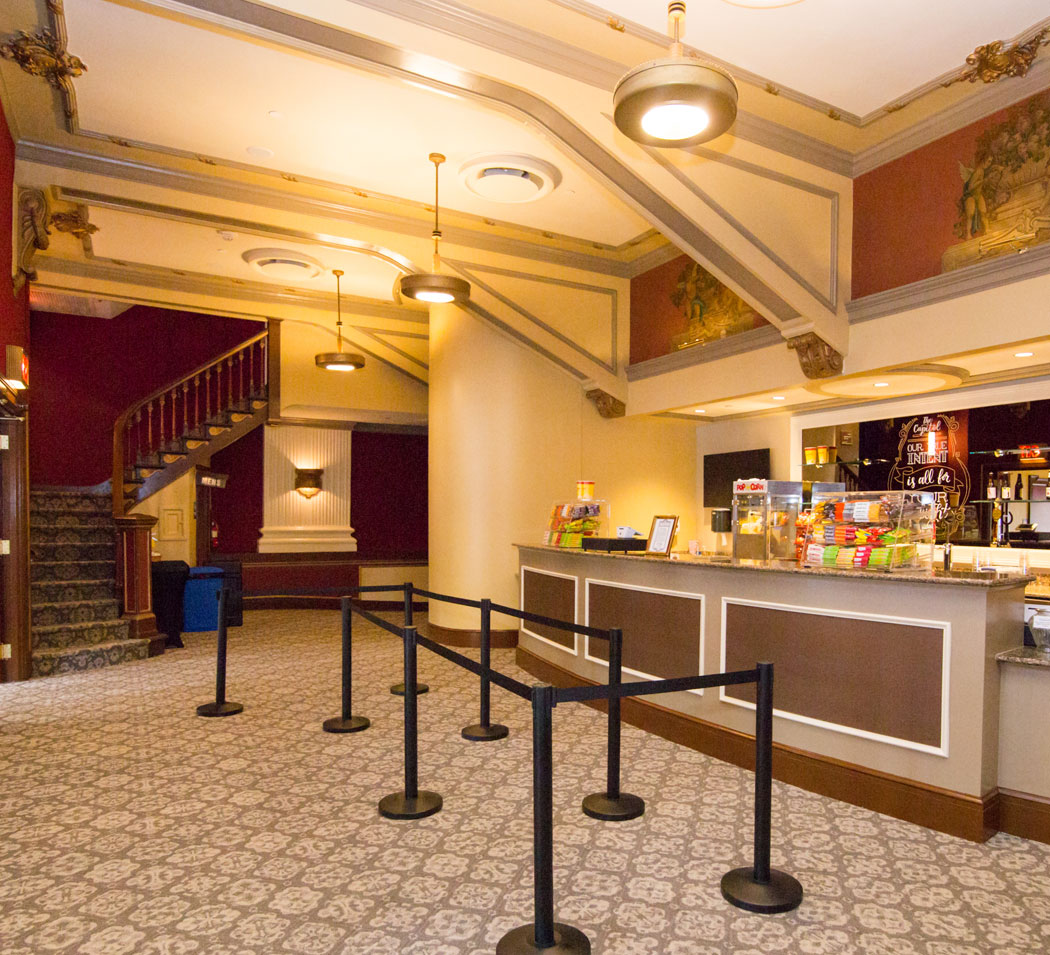 Interior image of the Capitol Theatre lobby with concessions and the stairway to the balcony.