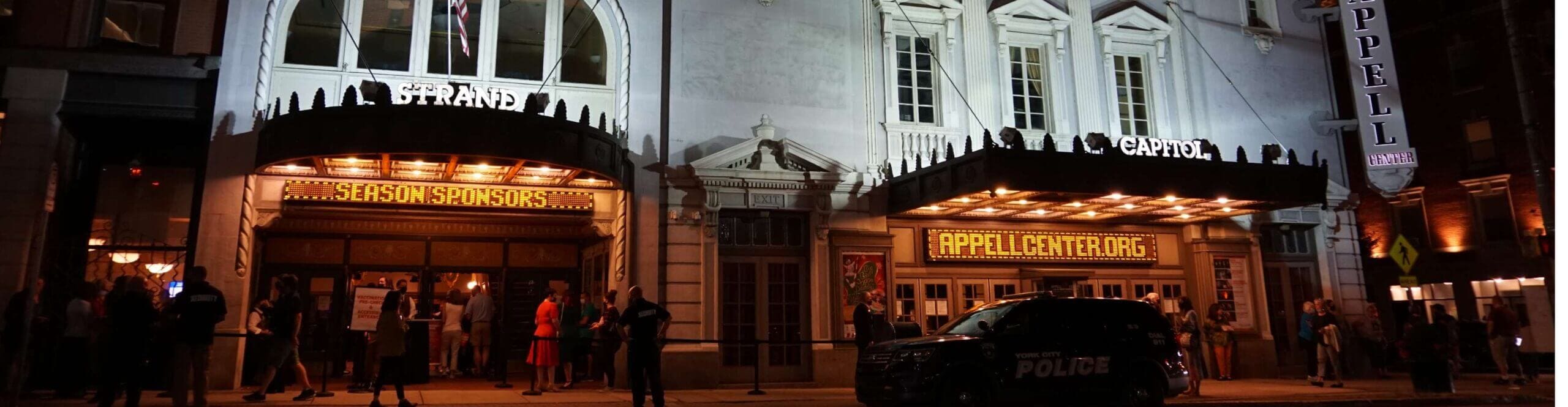 The exterior of the Strand Theatre and the Capitol Theatre at night