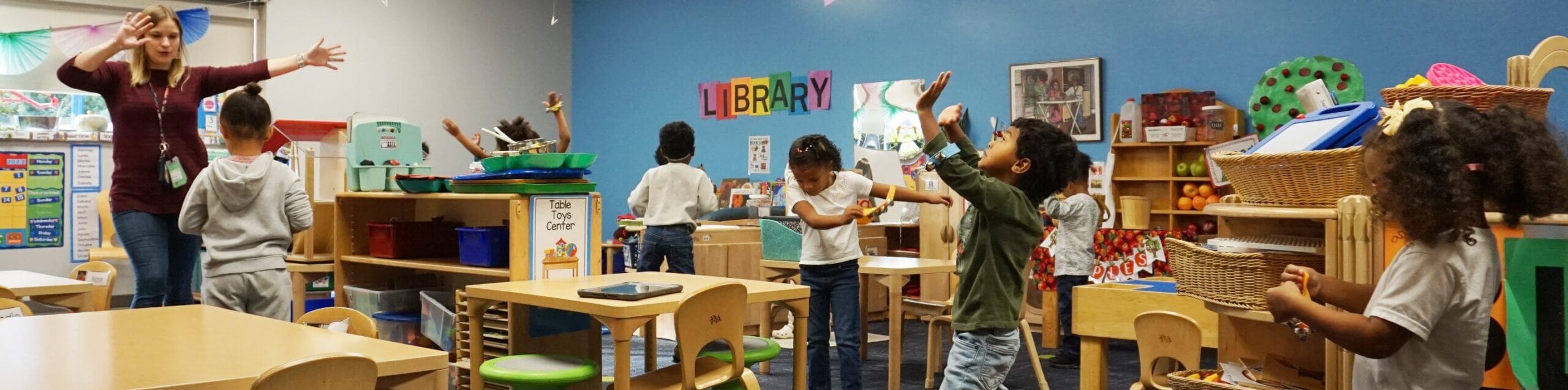 Students copy an instructor's body motions in their classroom.