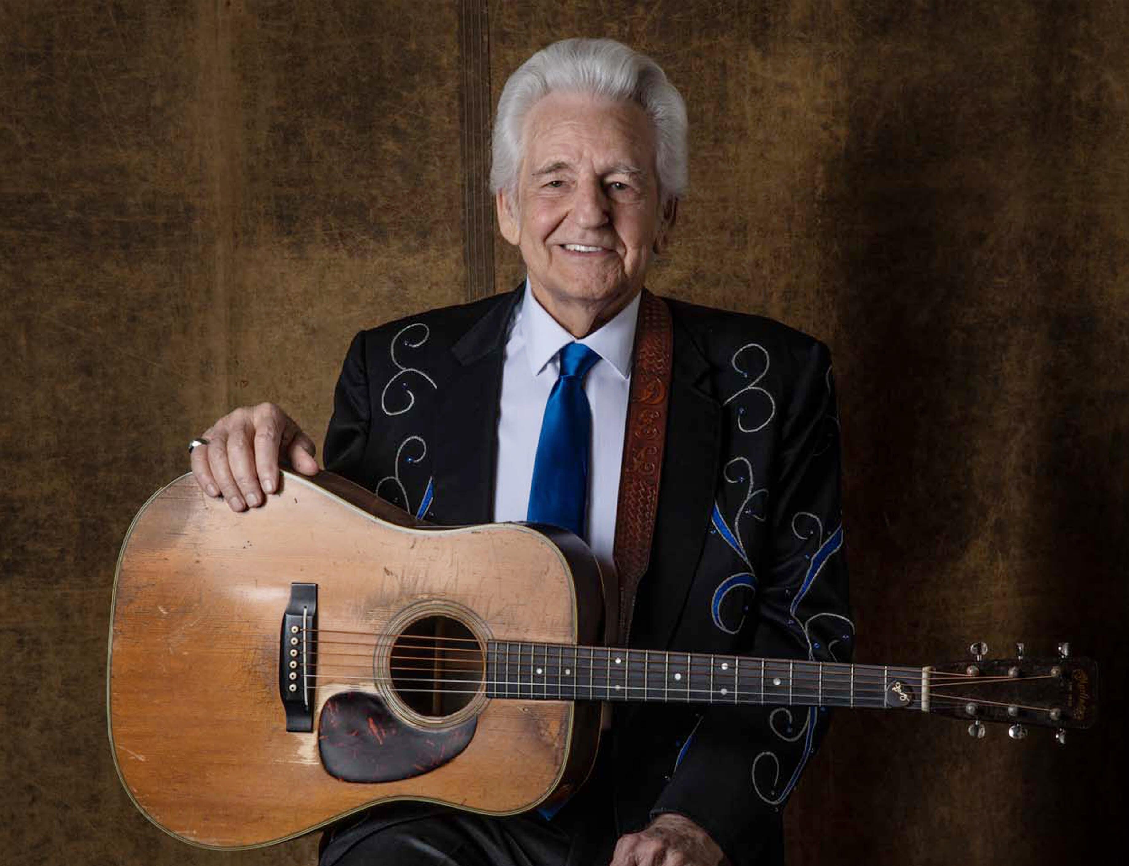 Del McCoury holding an acoustic guitar