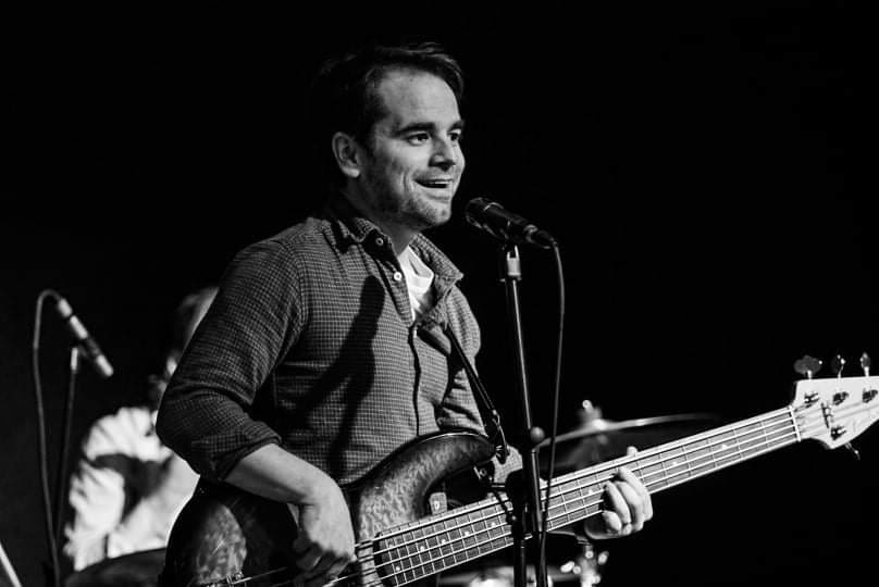 AJ Myers playing electric bass (black & white image)